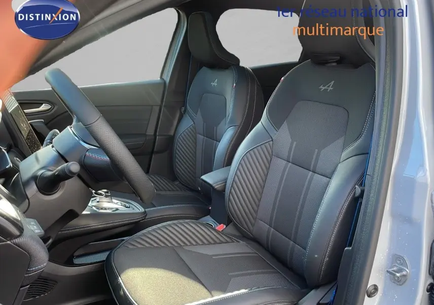 Intérieur avant du Renault Captur E-Tech hybride 2025 avec sièges noirs Alpine et détails gris, vue côté gauche porte ouverte.