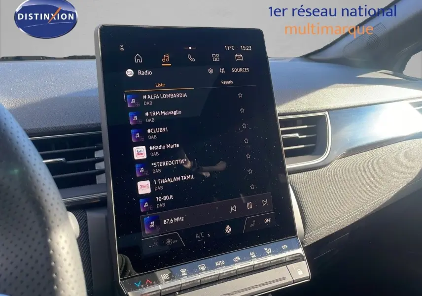 Vue intérieure du tableau de bord du Renault Captur E-Tech gris rafale, avec écran tactile central affichant la radio.
