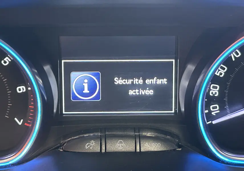 Gros plan sur le tableau de bord du Peugeot 2008 blanc, affichant "Sécurité enfant activée" sur l'écran central.