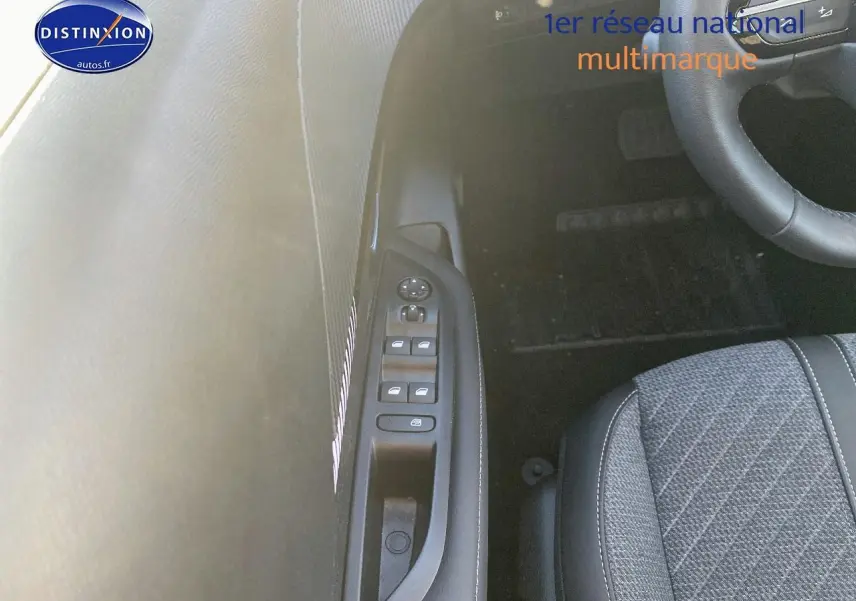 Vue intérieure sur le côté gauche du siège conducteur et la porte avec commandes des vitres d’une Peugeot 208 gris artense.