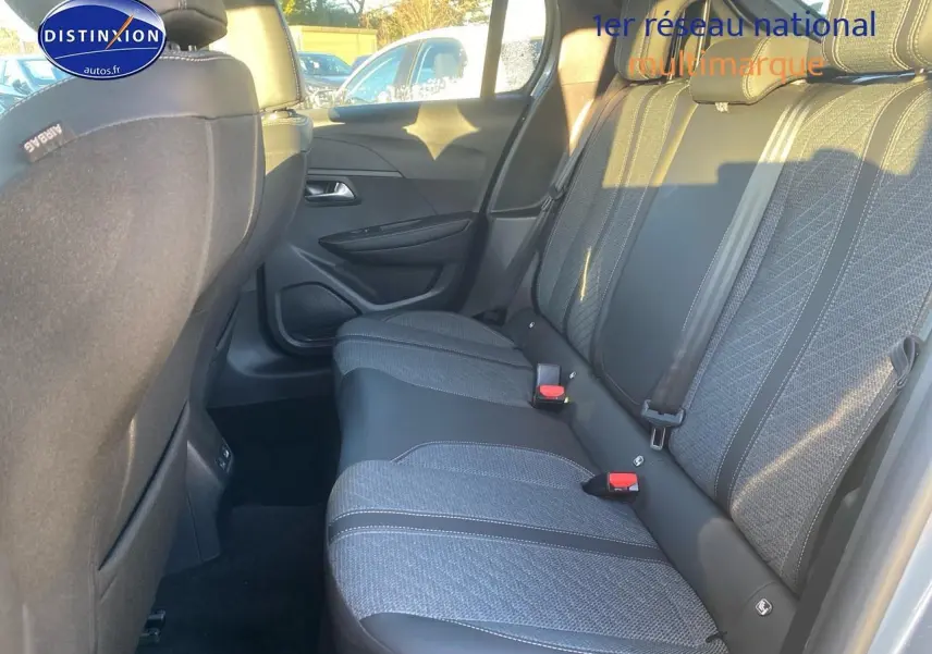 Vue côté droit de la banquette arrière grise de la Peugeot 208 1.2 hybrid 110 allure e-dcs6 avec ceintures et appuie-têtes.
