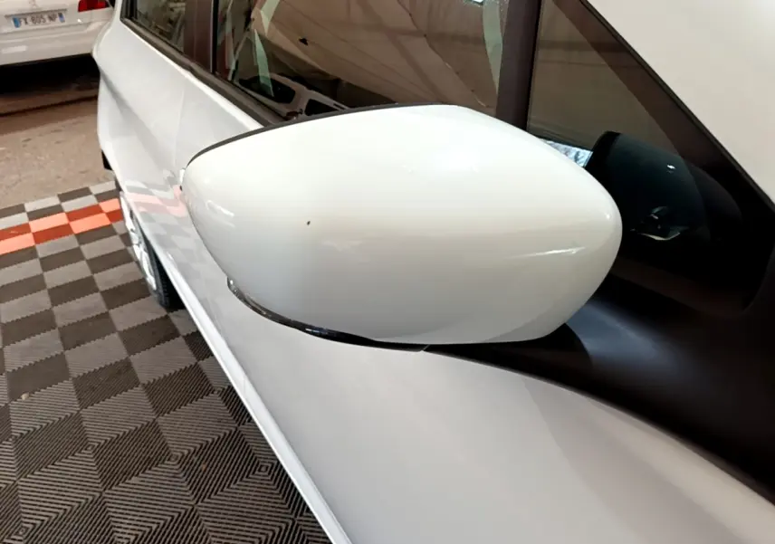 Gros plan sur le rétroviseur côté gauche blanc d'une Renault ZOE Business R110 blanche, vue partielle de la portière.