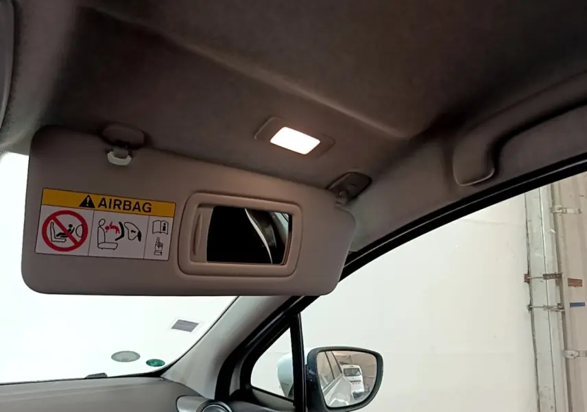 Vue intérieure du pare-soleil côté conducteur avec miroir et lumière allumée dans une Renault ZOE blanche de 2021.