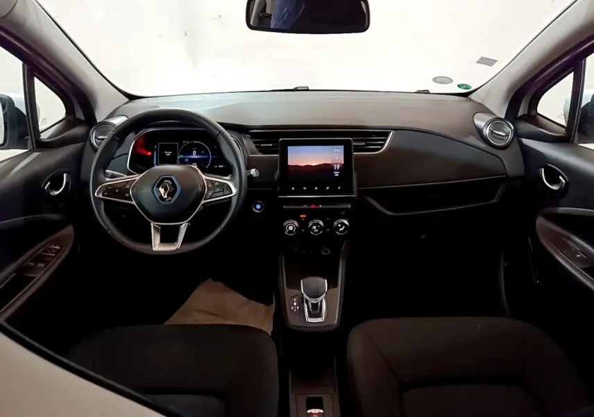 Vue intérieure frontale du tableau de bord noir de la Renault ZOE Business R110 avec écran tactile central et volant multifonctions.