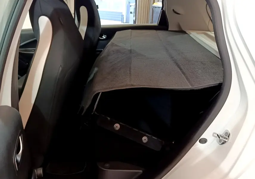 Vue intérieure côté droit de la Renault ZOE Business R110 blanche, banquette arrière rabattue et couverture grise.