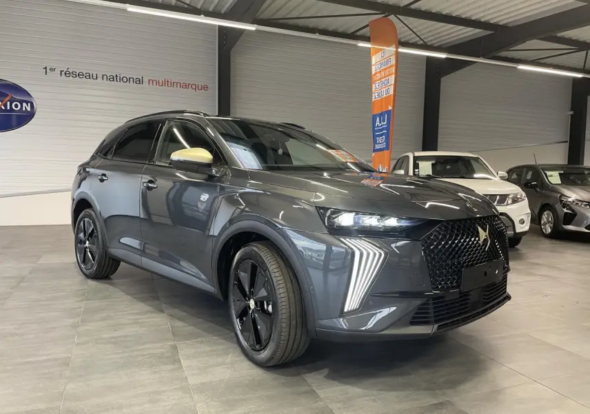 DS7 Crossback gris titanium en 3/4 avant droit, avec calandre noire et coques de rétroviseurs dorées satinées.