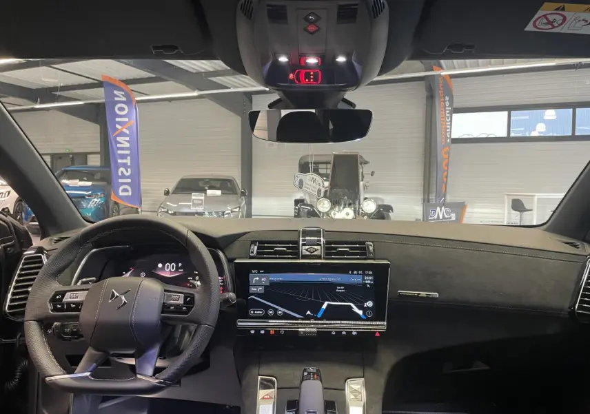 Vue intérieure avant du DS7 Crossback gris titanium, mettant en valeur le volant cuir perforé et l'écran tactile central.
