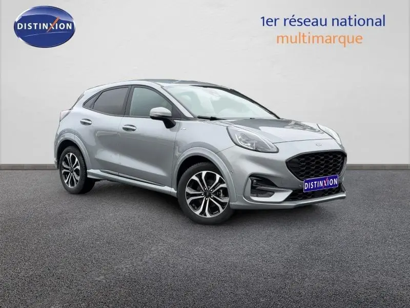 Ford Puma 2024 gris Solar métallisé en vue 3/4 avant droit avec jantes alu et calandre noire distinctive.