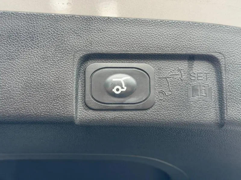 Bouton de fermeture électrique du hayon sur un Ford Puma gris Solar Métallisée, vue en gros plan intérieur coffre.