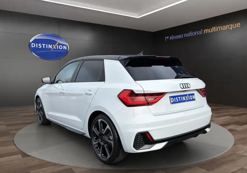 Audi A1 Sportback blanc avec toit noir, vue 3/4 arrière droit, jantes 18 pouces et feux LED distinctifs.