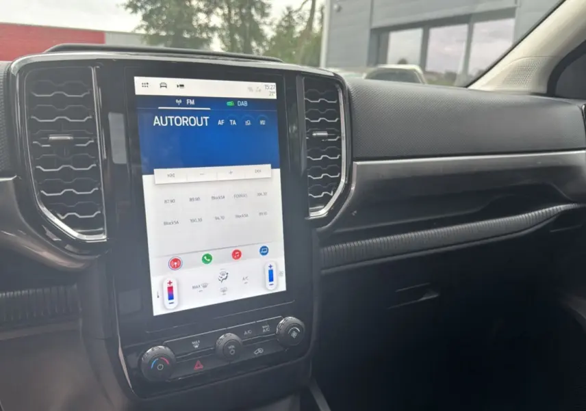 Vue intérieure du tableau de bord du Ford Ranger 2026 avec écran tactile vertical et commandes climatisation visibles.