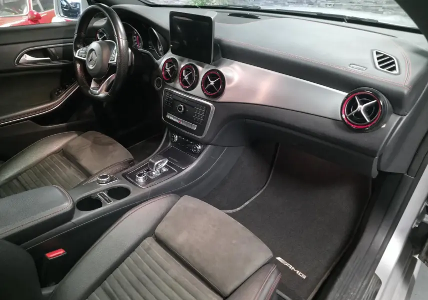 Intérieur avant droit de la Mercedes CLA Shooting Brake gris, avec aérateurs AMG cerclés de rouge et sellerie noire.