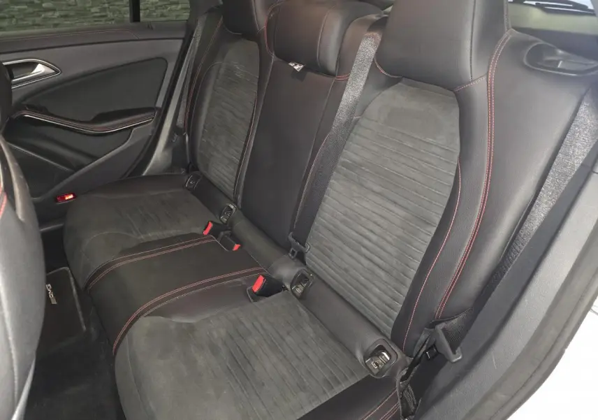 Vue intérieure côté droit des sièges arrière noirs en cuir et microfibre avec surpiqûres rouges d'une Mercedes CLA Shooting Brake AMG 2016.