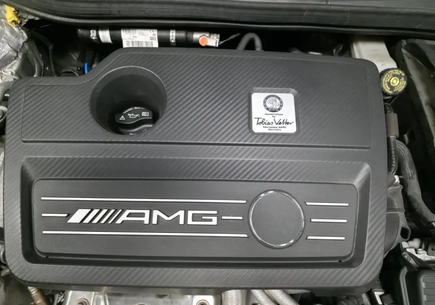 Vue rapprochée du moteur AMG noir avec plaque nominative Tobias Vetter sur Mercedes CLA Shooting Brake gris.