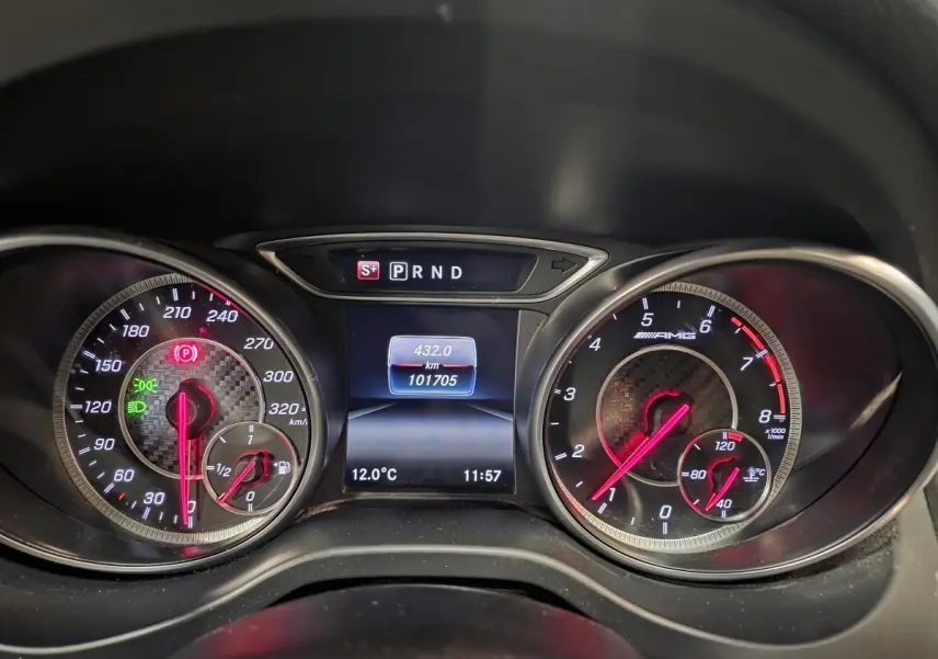 Vue rapprochée du combiné d'instruments AMG avec compte-tours, compteur de vitesse et écran digital affichant la température et le kilométrage.