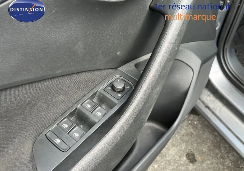 Détail des commandes des vitres et rétroviseurs sur la porte côté gauche d’une Skoda Scala gris magnétique 2025.