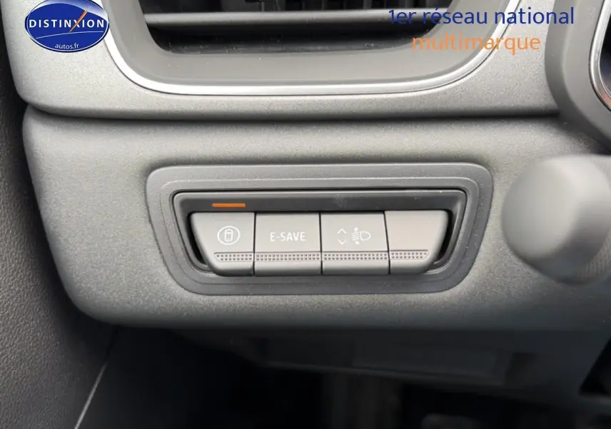 Gros plan sur les boutons de commande E-SAVE et réglage des phares dans l'habitacle de la Renault Symbioz bleu mercure.