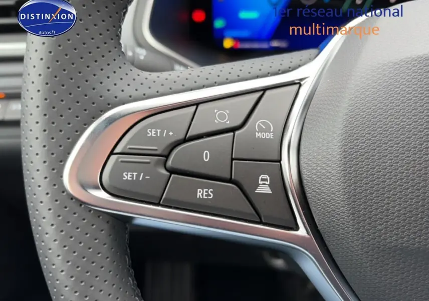 Gros plan sur les commandes du volant à gauche de la Renault Symbioz 2026, cuir perforé et boutons multifonctions noirs.