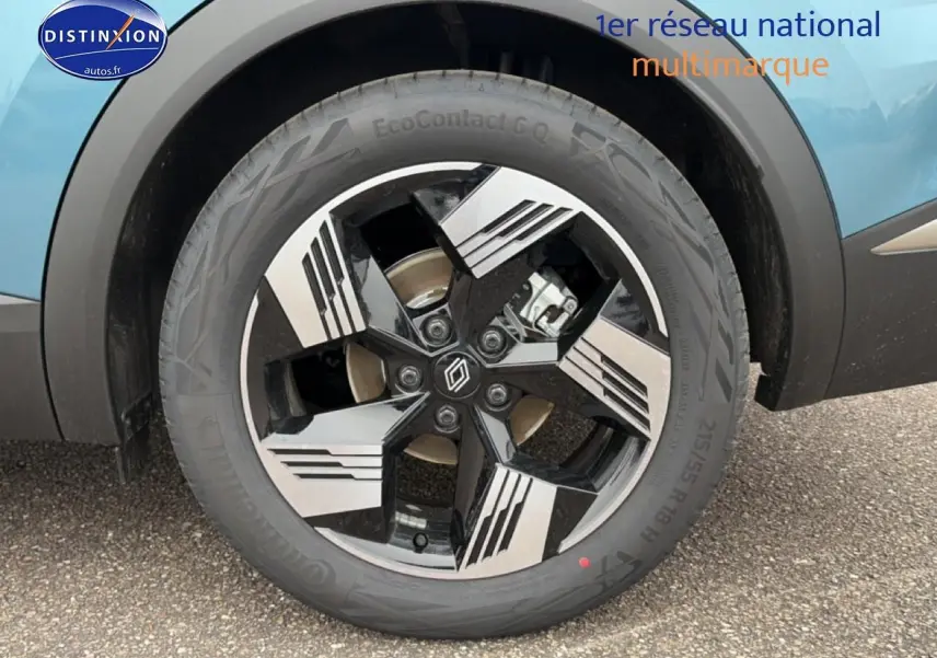 Gros plan sur la jante alliage 18 pouces bicolore noir et argent du côté gauche d’un Renault Symbioz bleu mercure.