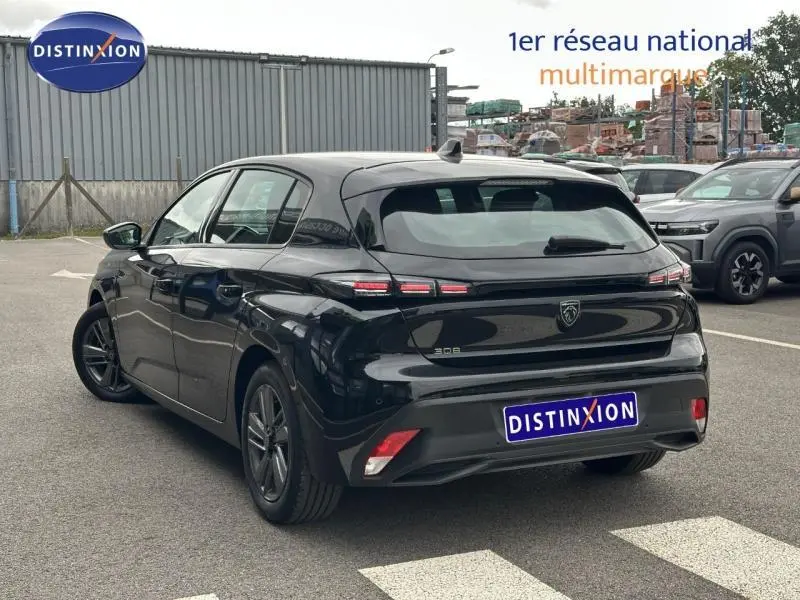 Vue 3/4 arrière droite d'une Peugeot 308 2024 noire Perla Nera avec feux arrière à triple griffes distinctifs.