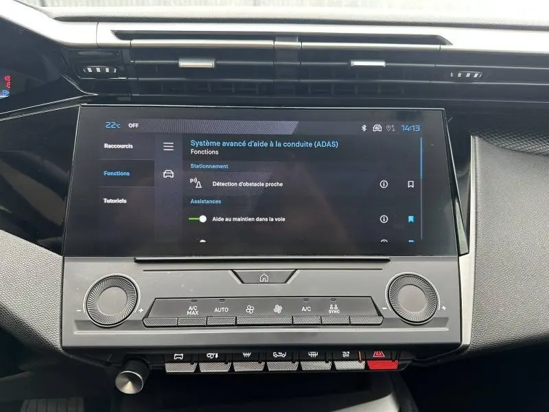 Vue rapprochée de l’écran tactile central et de la console de la Peugeot 308 2024 noir Perla Nera affichant les aides à la conduite.