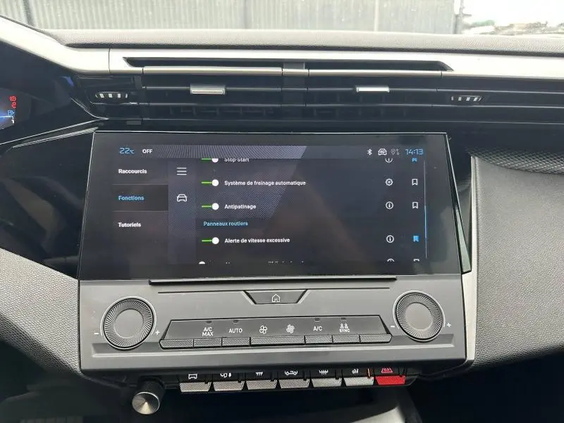 Vue rapprochée de l'écran tactile et de la console centrale noire du tableau de bord de la Peugeot 308 2024.