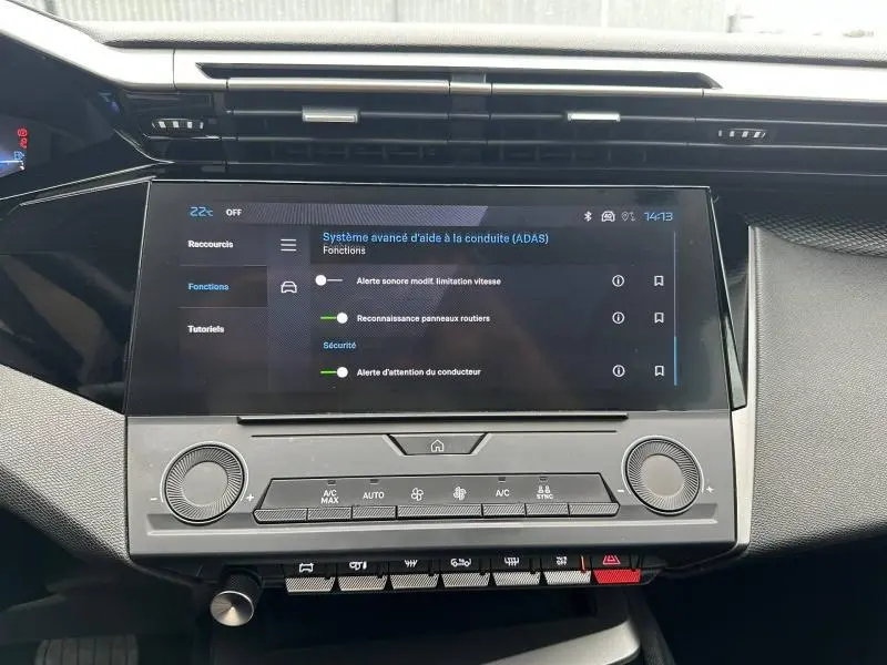 Vue rapprochée de l’écran tactile central et des commandes de climatisation du tableau de bord de la Peugeot 308 2024 noir Perla Nera.