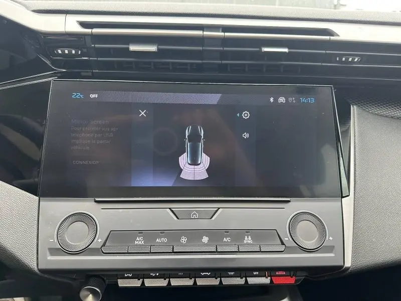 Vue rapprochée de l’écran tactile central et de la console de la Peugeot 308 2024 en Noir Perla Nera, affichant l’aide au stationnement.