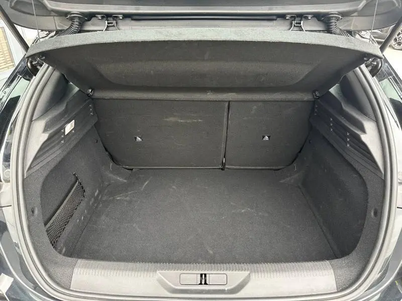 Coffre ouvert vu de l'arrière d'une Peugeot 308 2024 noir Perla Nera, montrant un espace de chargement propre et spacieux.
