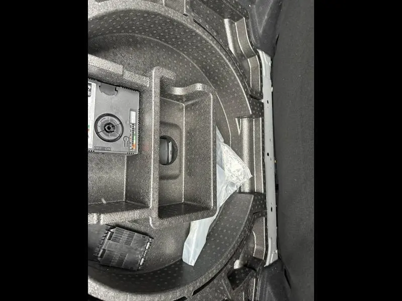 Rangement en mousse dans le coffre de la Peugeot 308 2024, vue plongeante sur l’espace de rangement noir.