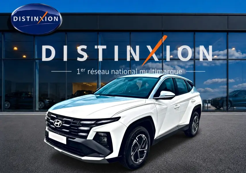 Hyundai Tucson blanc 2026 en 3/4 avant droit, avec calandre noire et jantes alliage 17 pouces visibles.