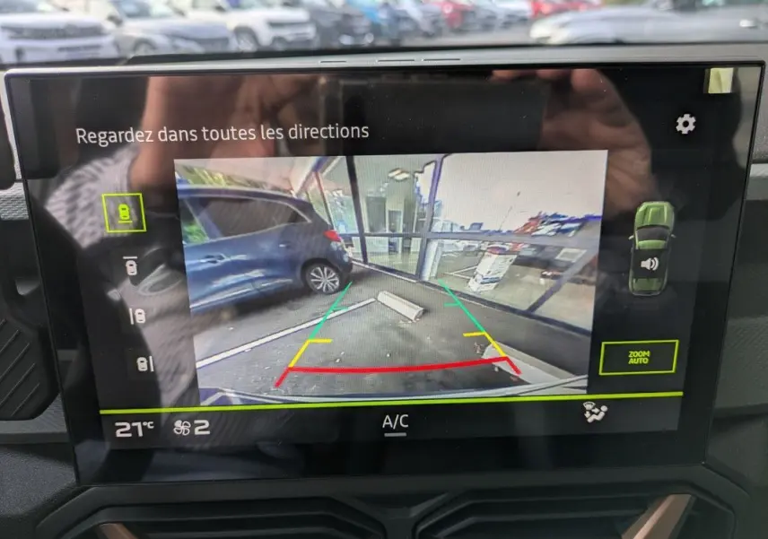 Écran de caméra de recul du Dacia Duster Hybrid 155 Extreme montrant l’arrière avec lignes de guidage colorées.