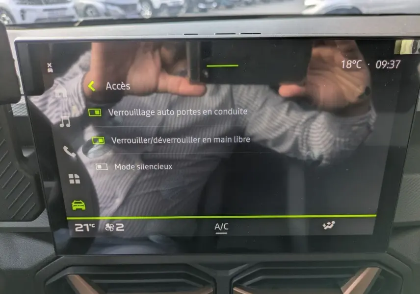 Écran tactile 10,1'' du Dacia Duster Hybrid 155 Extreme affichant les options de verrouillage, avec reflet d’une personne.