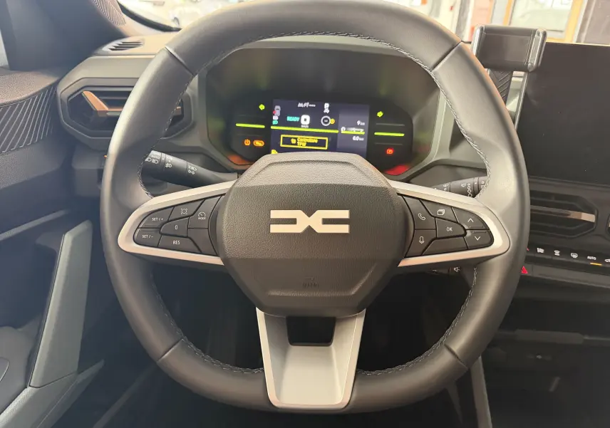 Vue centrée sur le volant du Dacia Duster Hybrid 155 Extreme 2026, avec commandes intégrées et tableau de bord numérique.
