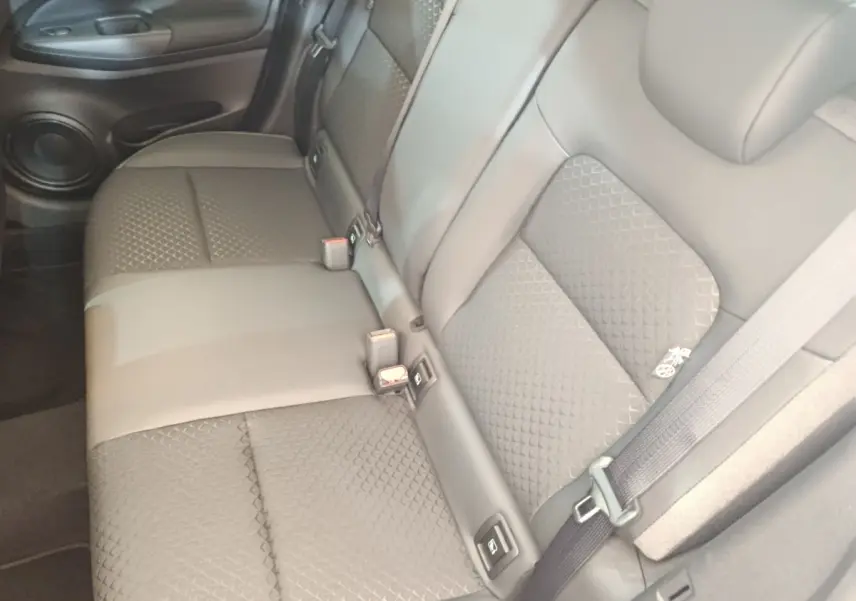 Vue rapprochée de la banquette arrière en cuir gris du Nissan Juke 2025, avec ceintures et fixation Isofix visibles.