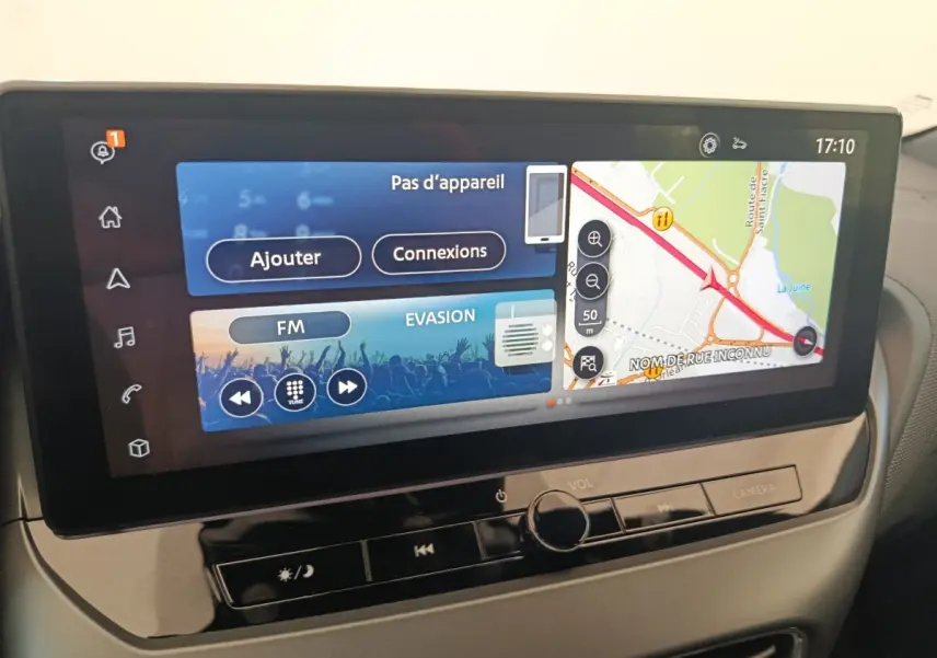 Écran tactile central 12,3 pouces du Nissan Juke 2025, affichant navigation et radio FM en intérieur noir.