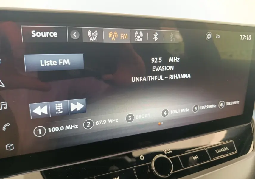Écran tactile central du Nissan Juke bleu 2025 affichant la radio FM avec station 92.5 MHz et titre musical visible.