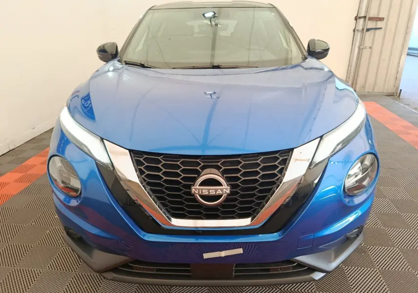Vue avant d'un Nissan Juke bleu 2025 avec calandre en nid d'abeille et phares LED distinctifs.