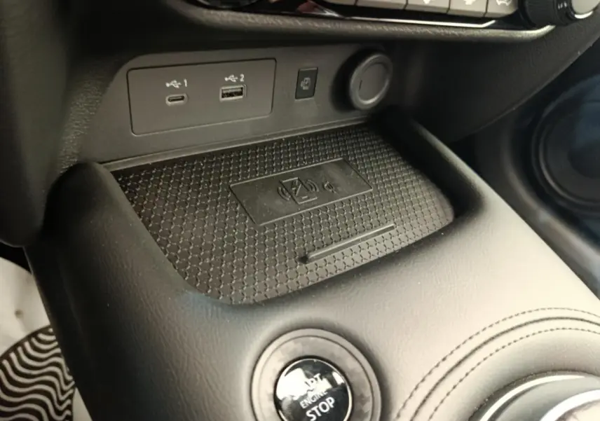 Gros plan sur la console centrale noire du Nissan Juke N-Connecta 2025 avec bouton start/stop et ports USB visibles.