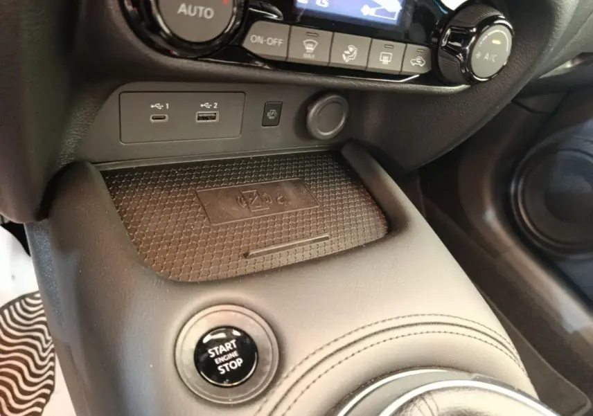 Gros plan intérieur sur la console centrale noire du Nissan Juke 2025, avec bouton Start/Stop et ports USB visibles.