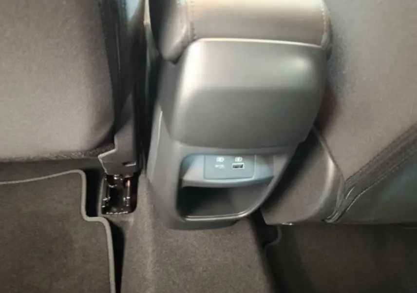 Prise USB et port 12V visibles sous l'accoudoir central arrière du Nissan Juke DIG-T 114 BVM6 N-Connecta 2025.