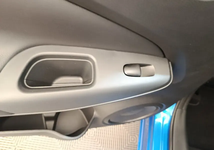Détail de la poignée intérieure côté gauche avec partie de la porte bleu vif d’un Nissan Juke 2025.