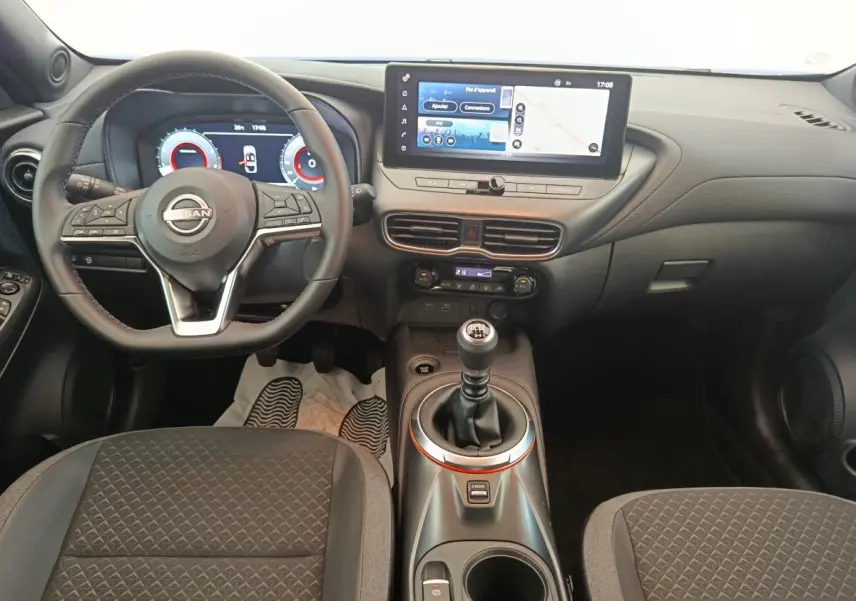 Vue intérieure du tableau de bord et volant du Nissan Juke 2025, avec écran tactile et levier de vitesses manuel.
