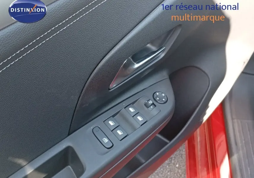 Gros plan sur la commande des vitres côté conducteur d’une Opel Corsa rouge Kardio métal avec intérieur noir.