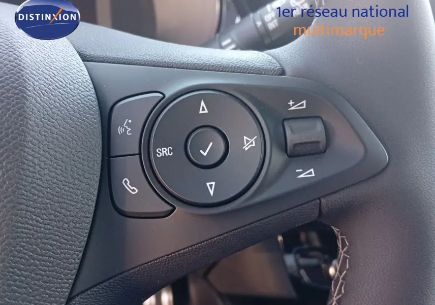 Gros plan sur les commandes multifonctions noires à gauche du volant d’une Opel Corsa 2023.