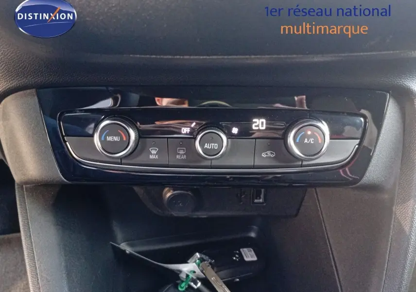 Gros plan sur la console centrale de l’Opel Corsa rouge Kardio Métal avec commandes de climatisation digitales.
