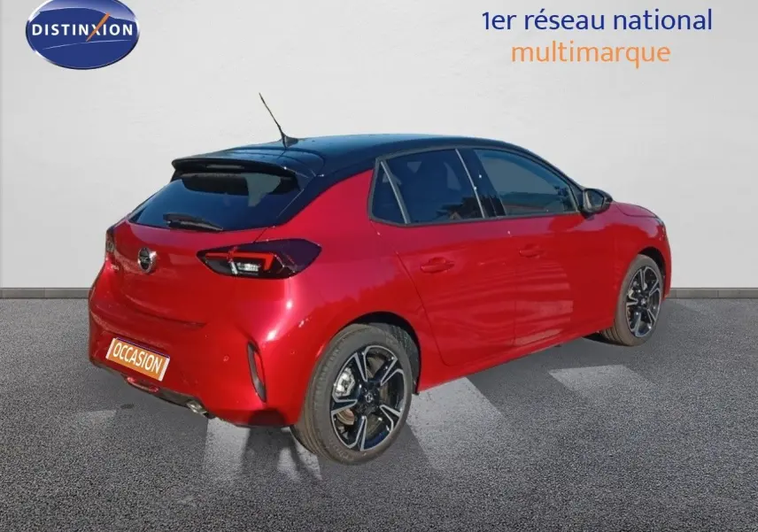 Vue 3/4 arrière droite d'une Opel Corsa rouge Kardio métal avec toit noir et jantes alliage biton.