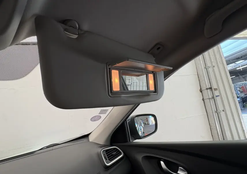 Détail intérieur du pare-soleil côté conducteur avec miroir éclairé sur Renault Kadjar gris foncé, vue côté gauche.