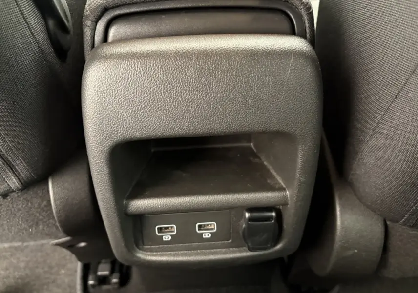 Gros plan sur la console arrière noire du Renault Kadjar 2019, avec deux ports USB visibles entre les sièges arrière.