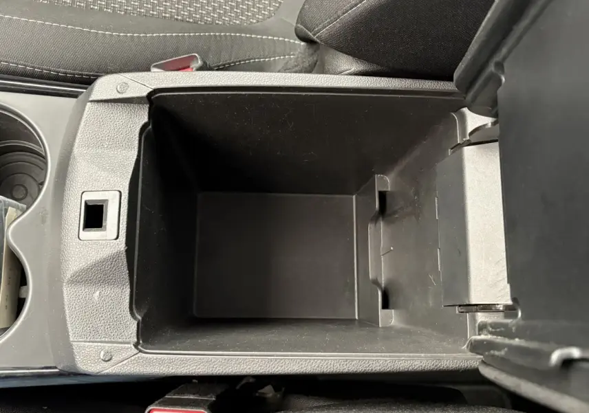 Vue plongeante sur le rangement central noir ouvert de la Renault Kadjar Intens gris foncé, intérieur tissu gris.